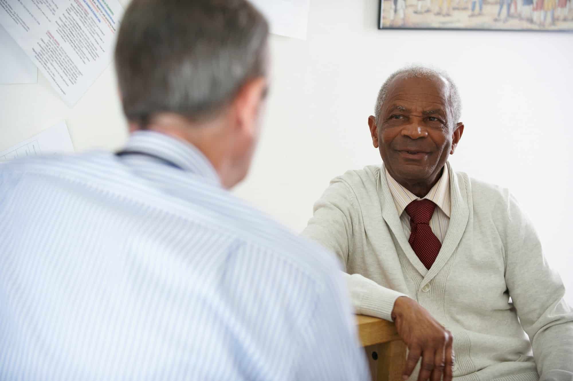 Elderly black man talking to doctor