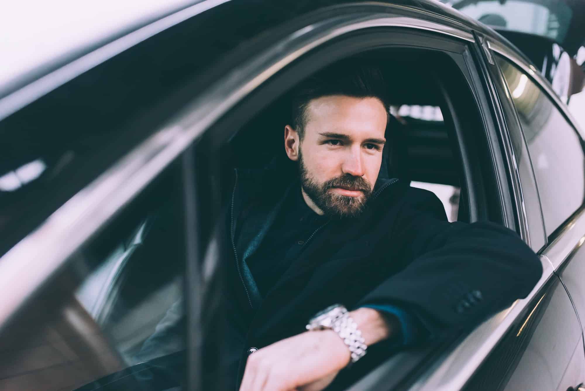 young bearded businessman sitting car