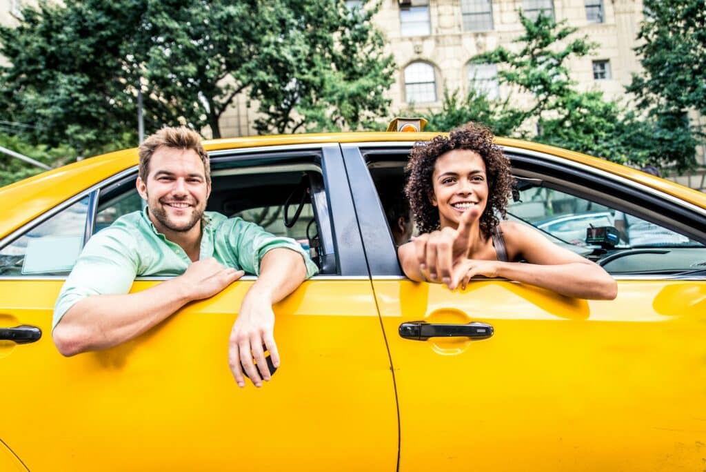 Man en vrouw die uit raam van taxi hangen - Taxipas verlengen | Rikbewijsdokter
