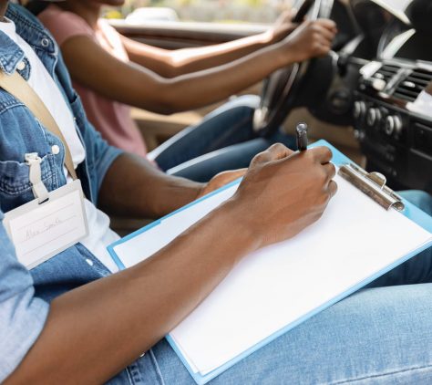 driving-instructor-taking-notes-during-exam-drivi-2021-09-04-11-59-43-utc
